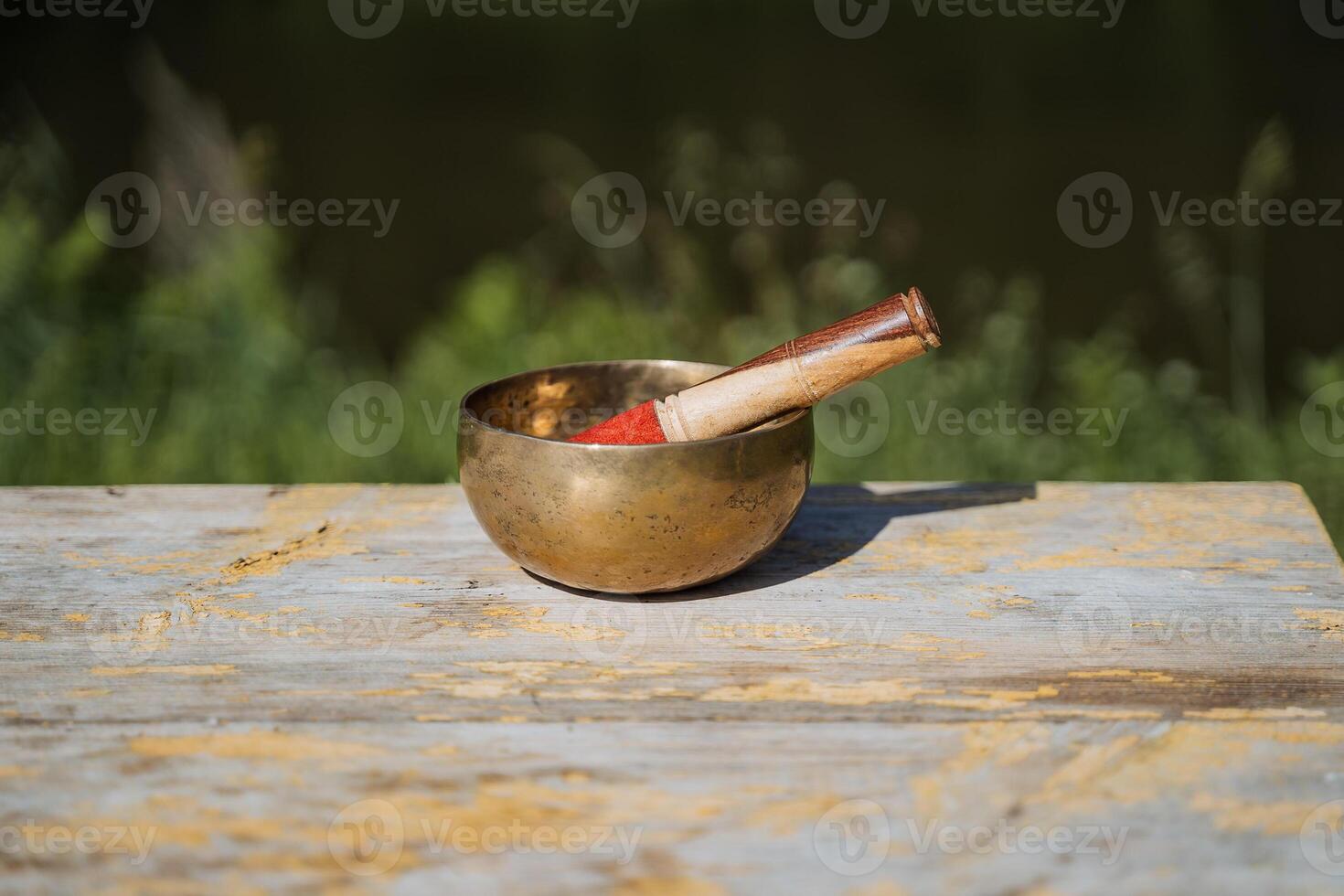 Tibetan bowl on the background of nature, metal bronze bowl musical instrument creating vibrations, yoga in nature meditation photo