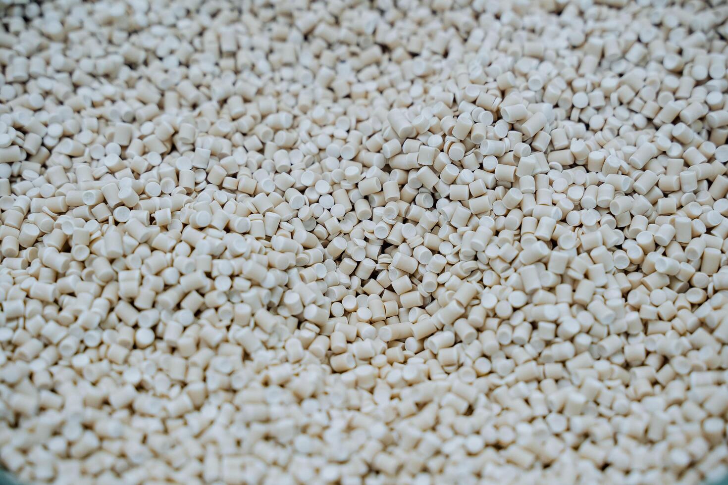 Granules of white plastic shot close-up, a pile of small crumbs of plastic, components of petrochemical production, raw materials for the manufacture of parts and PVC photo