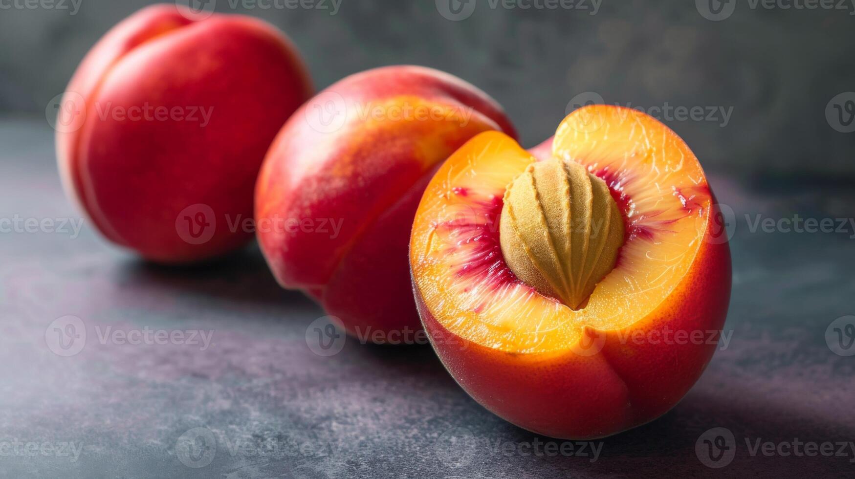 Ripe nectarine with juicy red flesh and yellow stone on a textured background photo