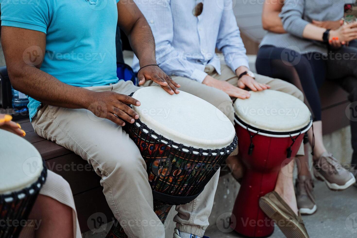 Musicians drum on the street, a large black guy beats the rhythms of Africa on a djemba, pumped muscles, biceps. photo