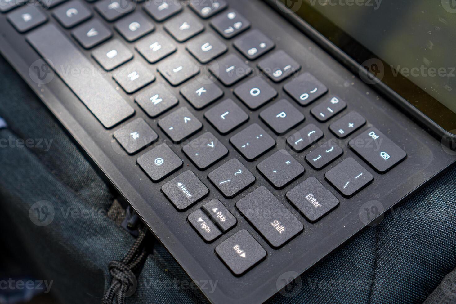 Close-up view of a keyboard for a tablet on a table, in an open room. photo