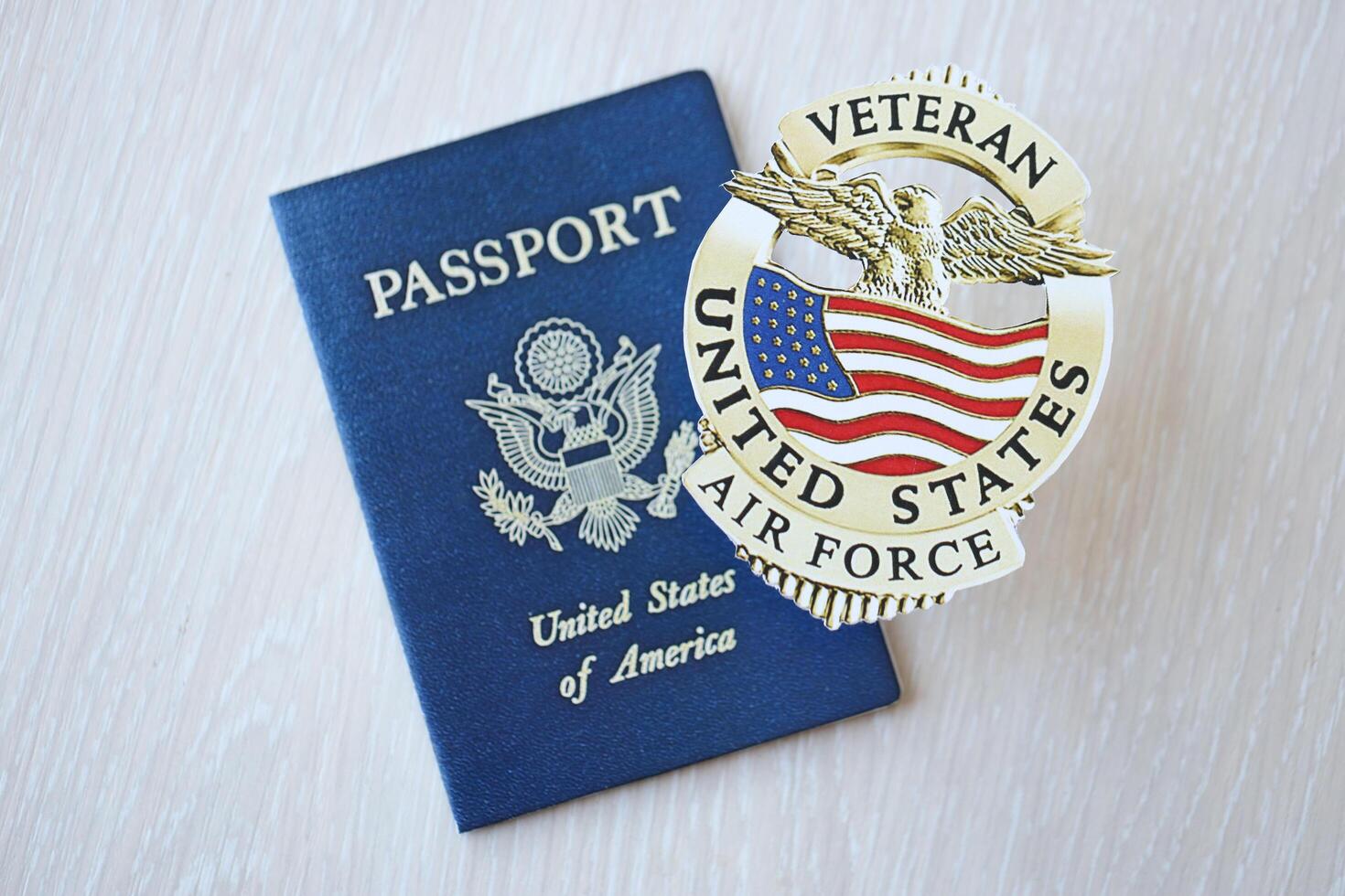 KYIV, UKRAINE - MARCH 9, 2024 US Air Force Veteran badge and United States passport on wooden table photo