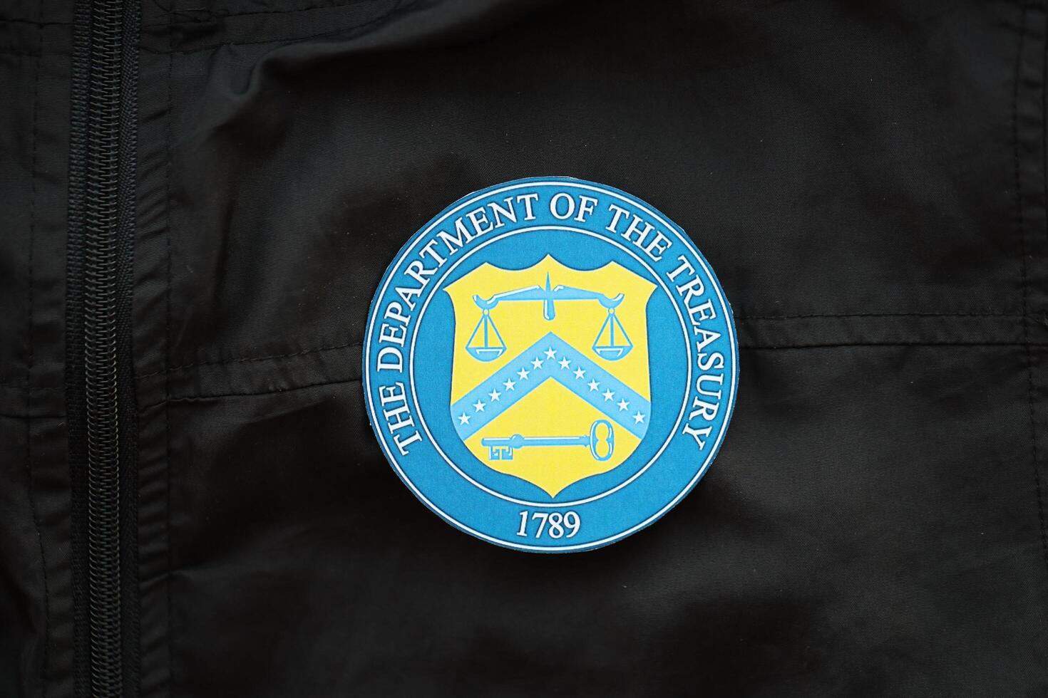 KYIV, UKRAINE - MARCH 9, 2024 US The Department of the Treasury seal on black jacket uniform photo