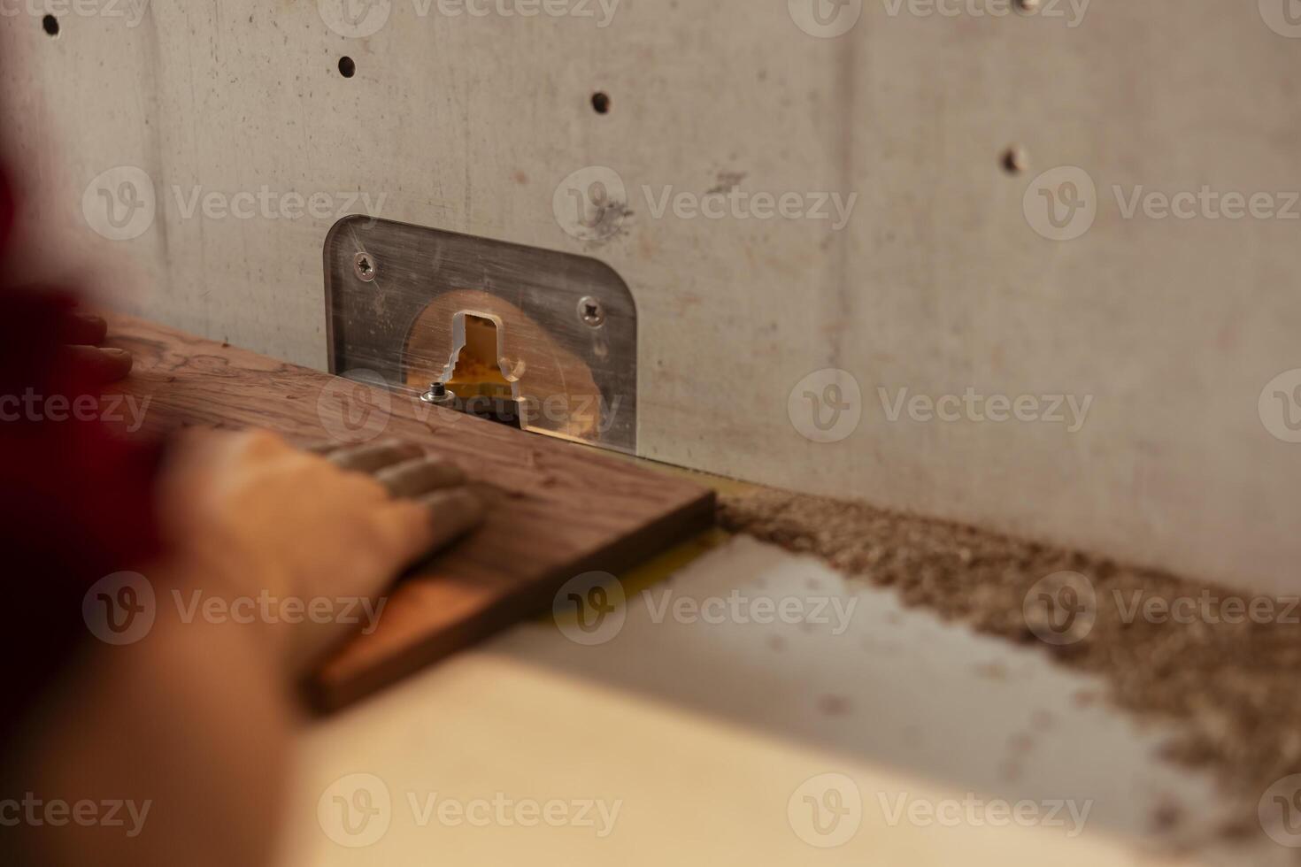 Woodworker operating spindle moulder to create high quality bespoke joinery for customer commissioned project. Machinist performing tasks on wood shaper, shaping and cutting materials, close up shot photo