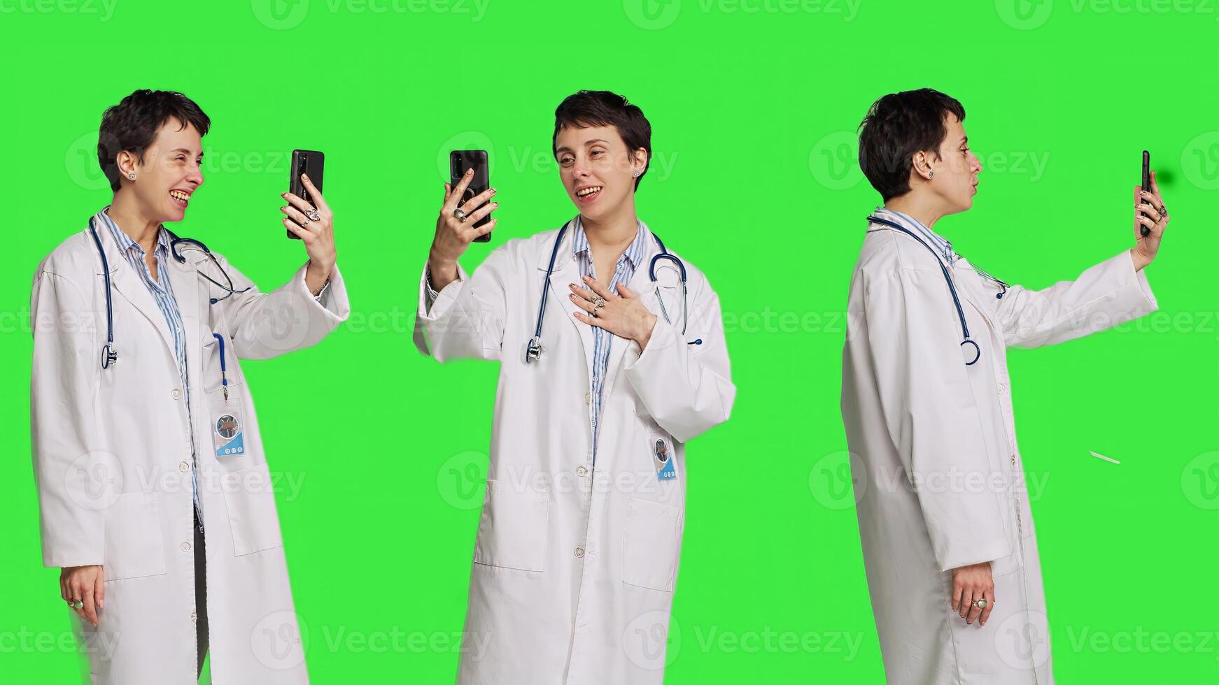 Medic specialist having remote call conversation with patients on smartphone internet connection, greenscreen backdrop. Doctor discusses about disease with people on conference. Camera B. photo