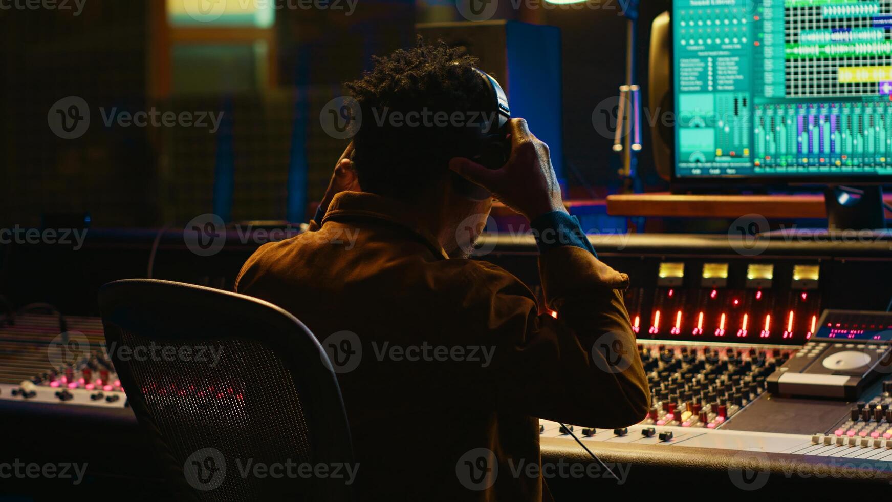 African american sound designer removing tonal imbalances and white noise on recorded files, music industry post production in professional studio. Control room expert editing tracks. Camera A. photo