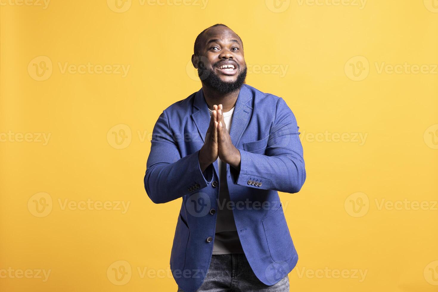 Cheerful african american man putting hands together in appreciation gesture, saying thank you. Happy BIPOC man doing praising gratitude gesturing, isolated over studio background photo