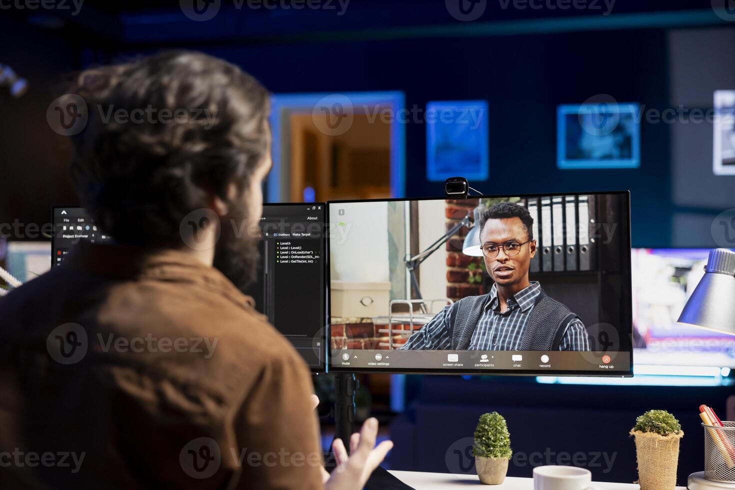 IT specialist working from home in videocall with coworker, testing and deploying programs and systems. Programmer checking code with colleague in teleconference, sitting at desk chair in apartment photo