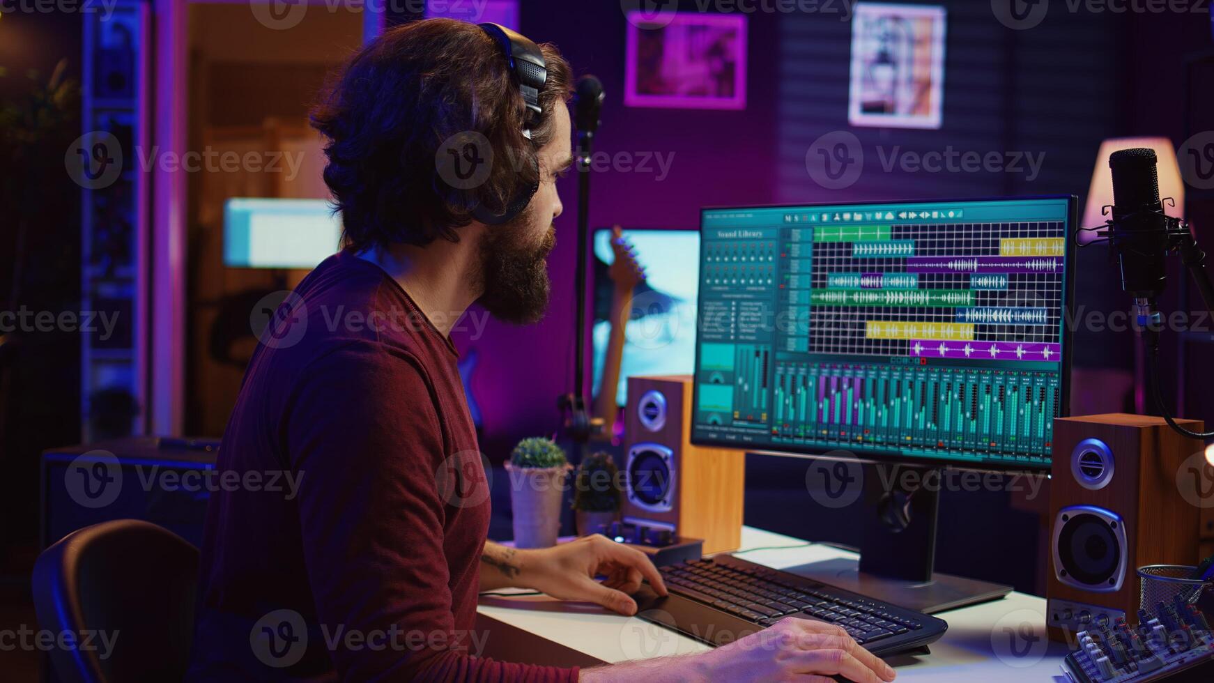 Music composer producing soundtracks using stereo panel controls and soundboard, twisting pre amp knobs for mixing and mastering tunes. Sound engineer adjusting volume in home studio. Camera B. photo