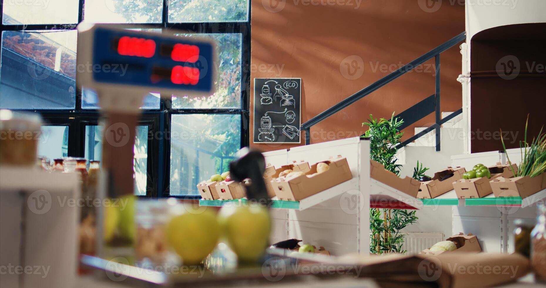 Low carbon footprint merchandise in local grocery store, checkout counter with electronic weighting scale at cash register. Small business farmers market supporting organic farming. Handheld shot. photo