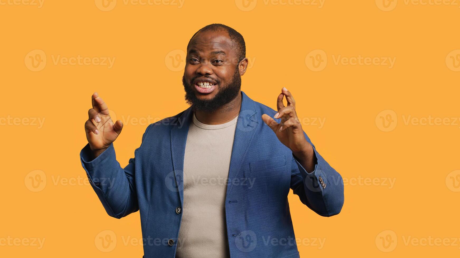 Portrait of upbeat african american man crossing fingers, making wish, isolated over yellow studio background. Jolly BIPOC person hoping for good luck, waiting for miracle, camera A photo