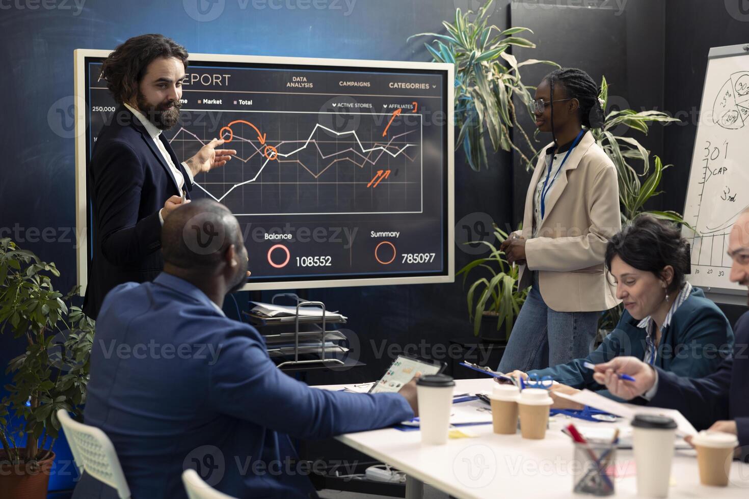 Marketing team assembling in an information sharing meeting to review updates on regulatory changes or industry standards. Business employees reviewing data analysis infographics. photo