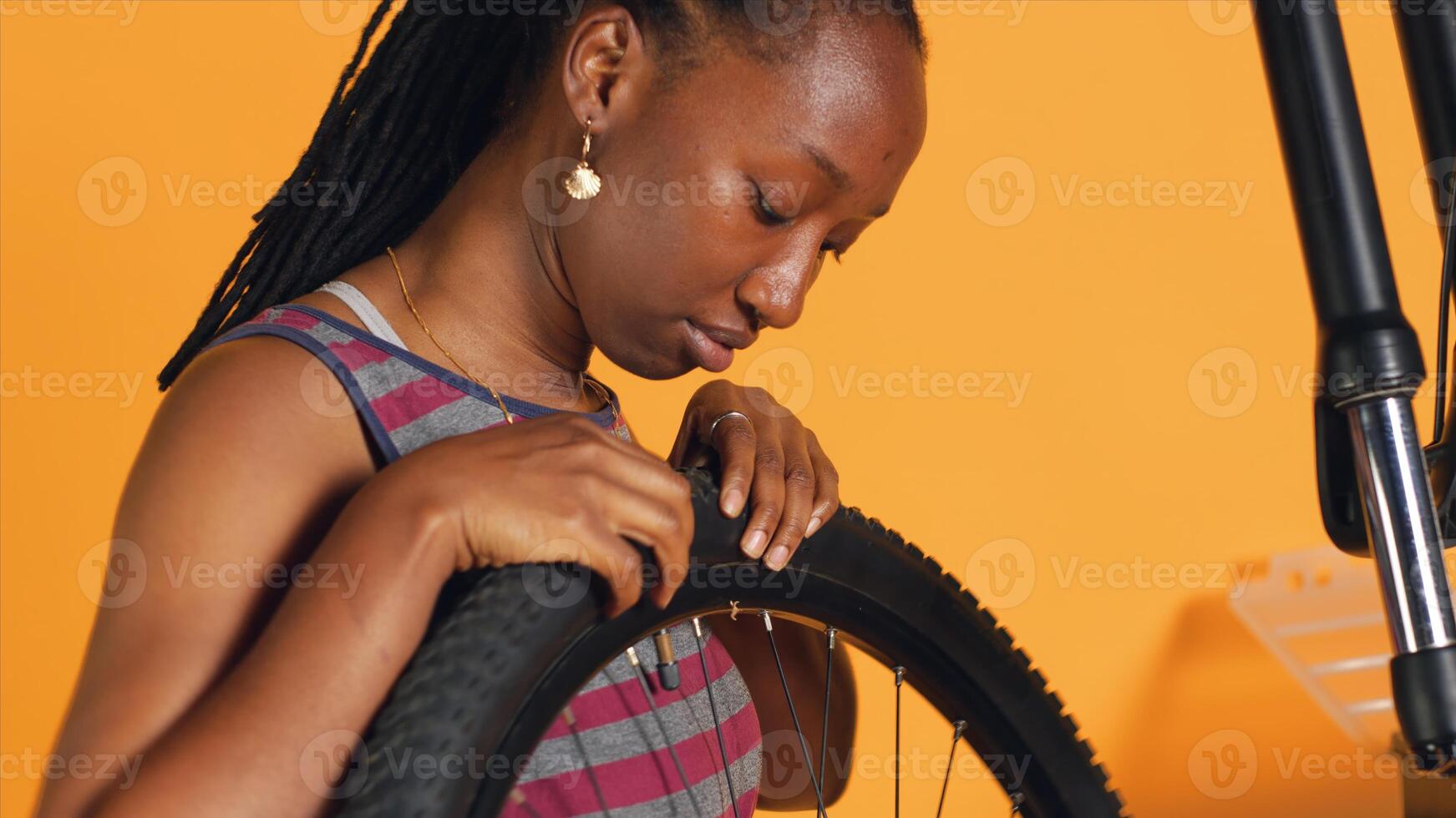 Skilled expert detaching bicycle wheel and adjusting handlebar in studio background repair shop. Close up shot of engineer disassembling bike tire, repairing components with professional equipment photo
