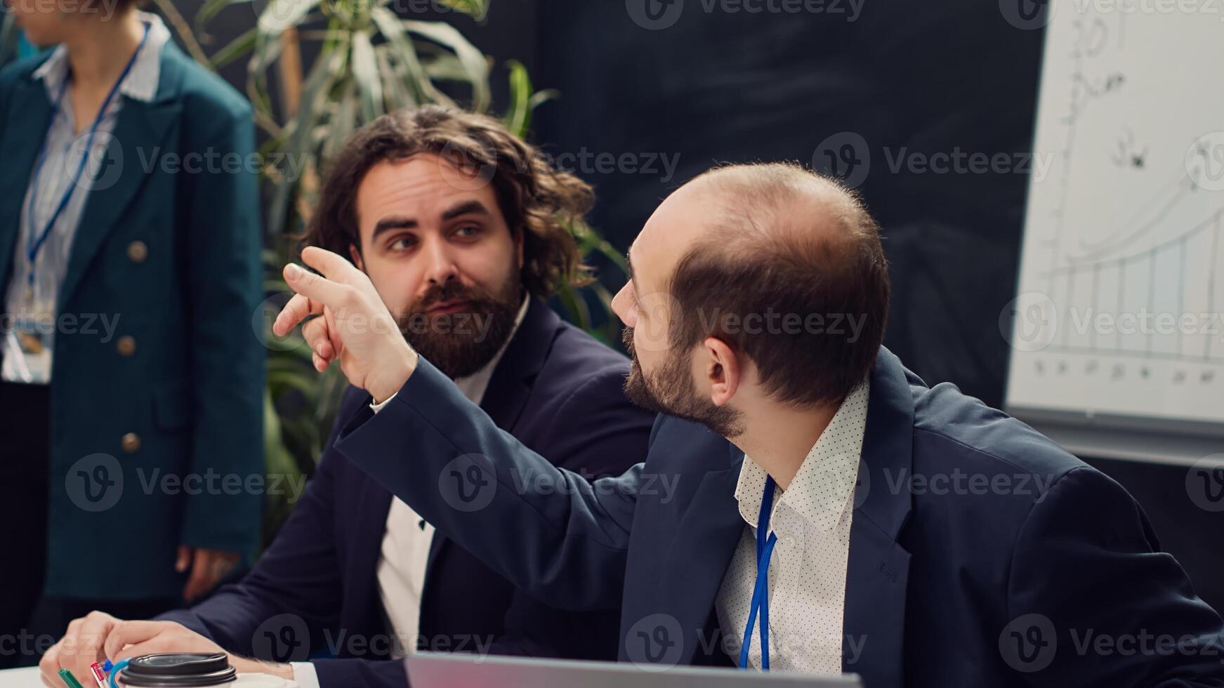 Startup team reviewing the organization position within the market, conducting an analysis or benchmarking exercises. Enterprise colleagues discuss activities for organizational growth. Camera A. photo