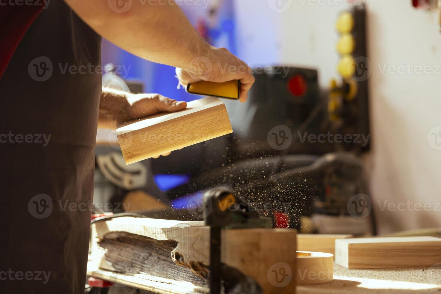 Craftsperson at workbench using manual sandpaper to sander lumber block, assembling furniture in woodworking shop. Carpenter smoothing piece of wood, enjoying diy hobby, close up photo