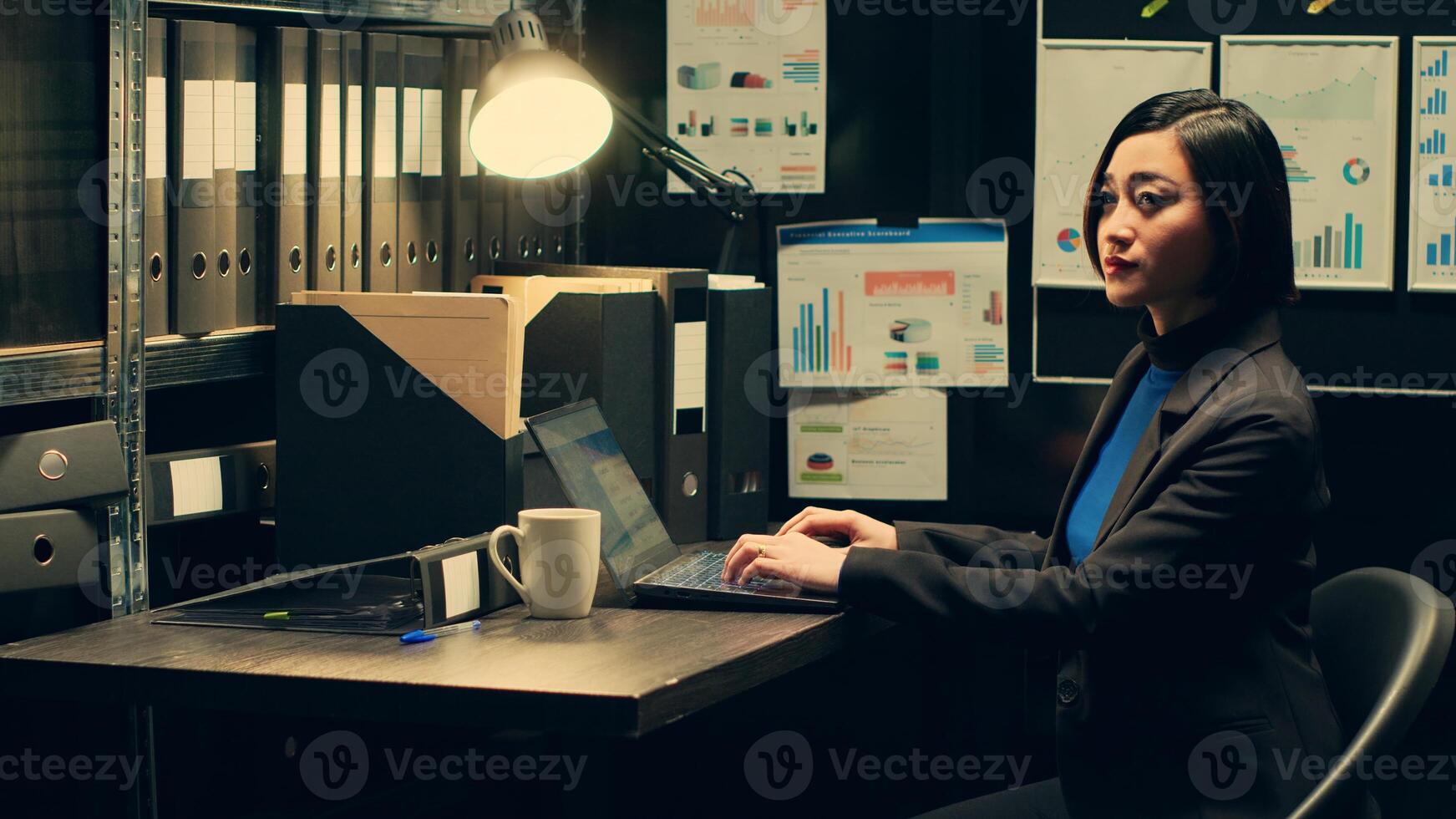 Portrait of investigator scrutinizes witness statements stored in the archives, working in police evidence room to find new clues and solve criminal case. Asian law enforcement officer. Camera A. photo