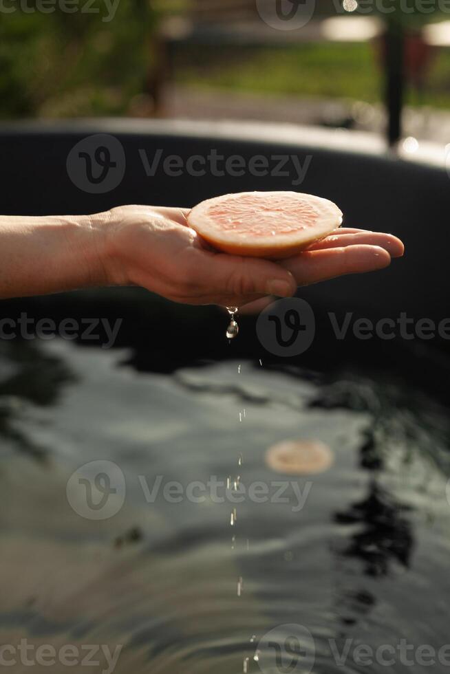 A hand splashes in a fragrant vat of citrus photo