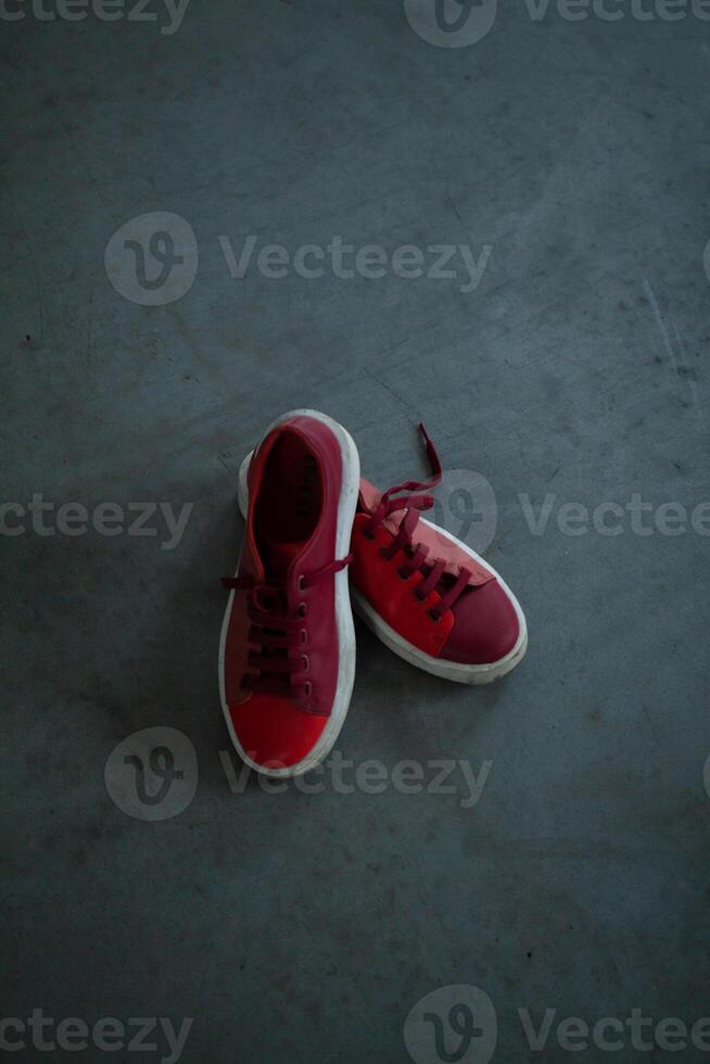 Red bright sneakers on a gray concrete floor photo