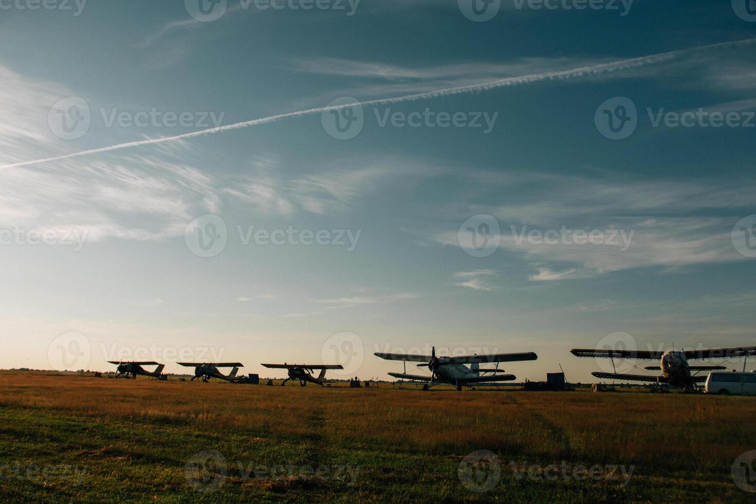 A number of aircraft lined up in an airfield photo