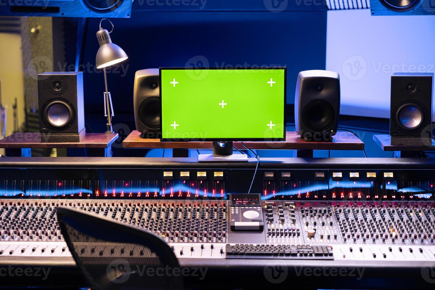 Empty studio control room with greenscreen isolated monitor, professional panel board and technical equipment used in music post production. Equalizer and sliders on soundboard. photo