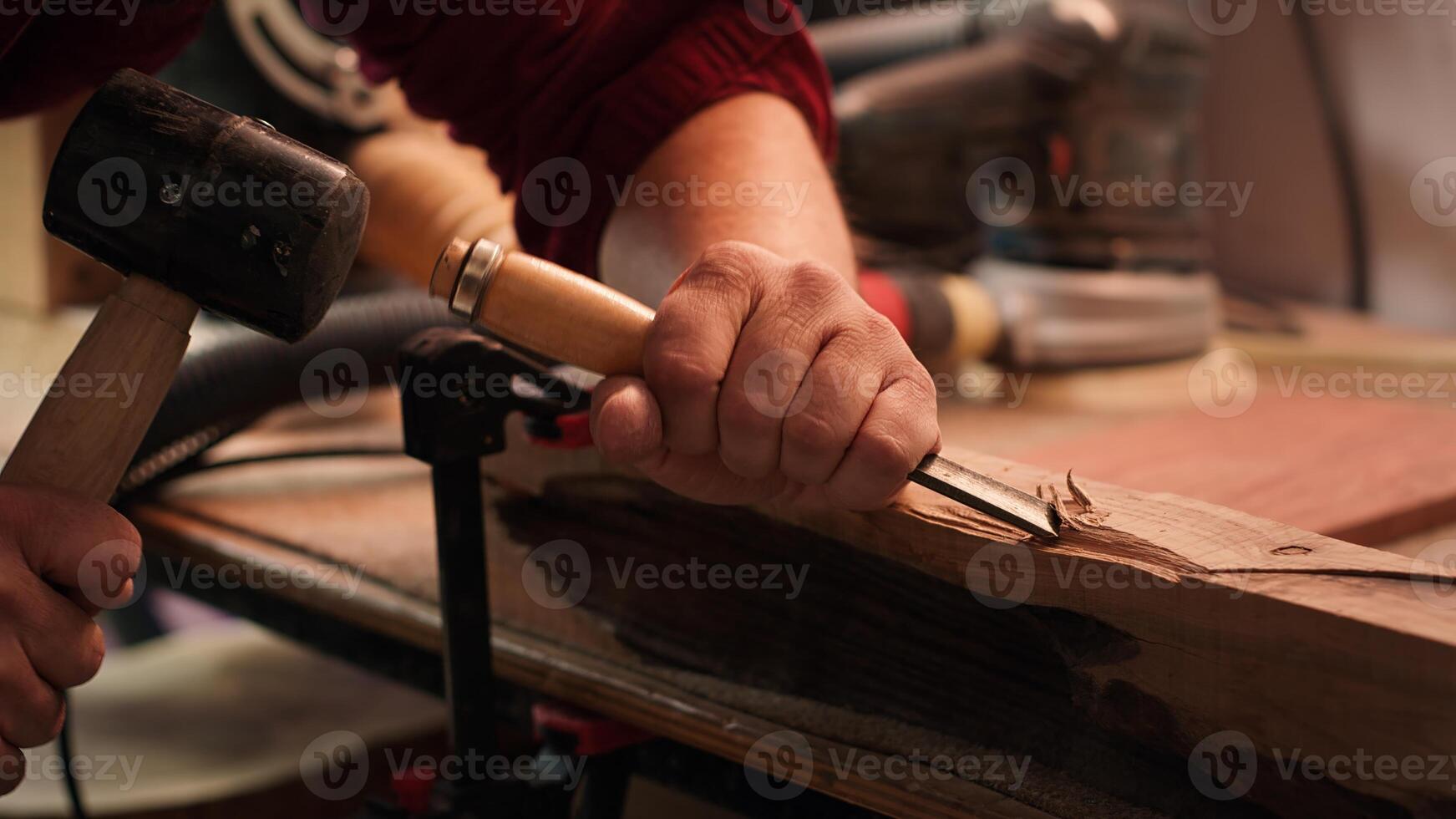 Craftsperson carving into wood using chisel and hammer in carpentry shop with precision. Manufacturer in studio shaping wooden pieces with tools, making wood art, camera A close up shot photo