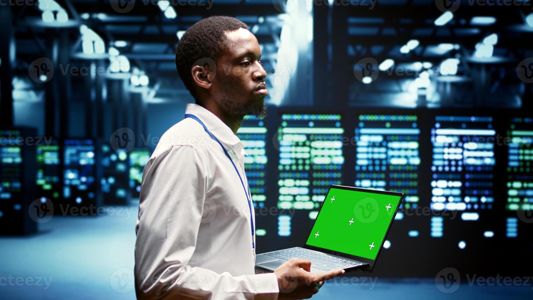 Engineer using green screen laptop to do maintenance on high bandwidth, dedicated game servers used to accommodate incoming traffic of online users joining from worldwide locations. photo