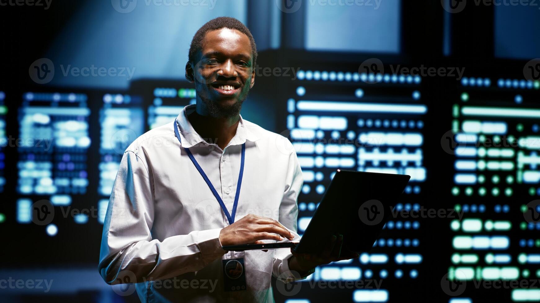 System administrator using laptop to audit servers in high tech facility providing computing resources, enabling artificial intelligence to process massive datasets for training and machine learning photo