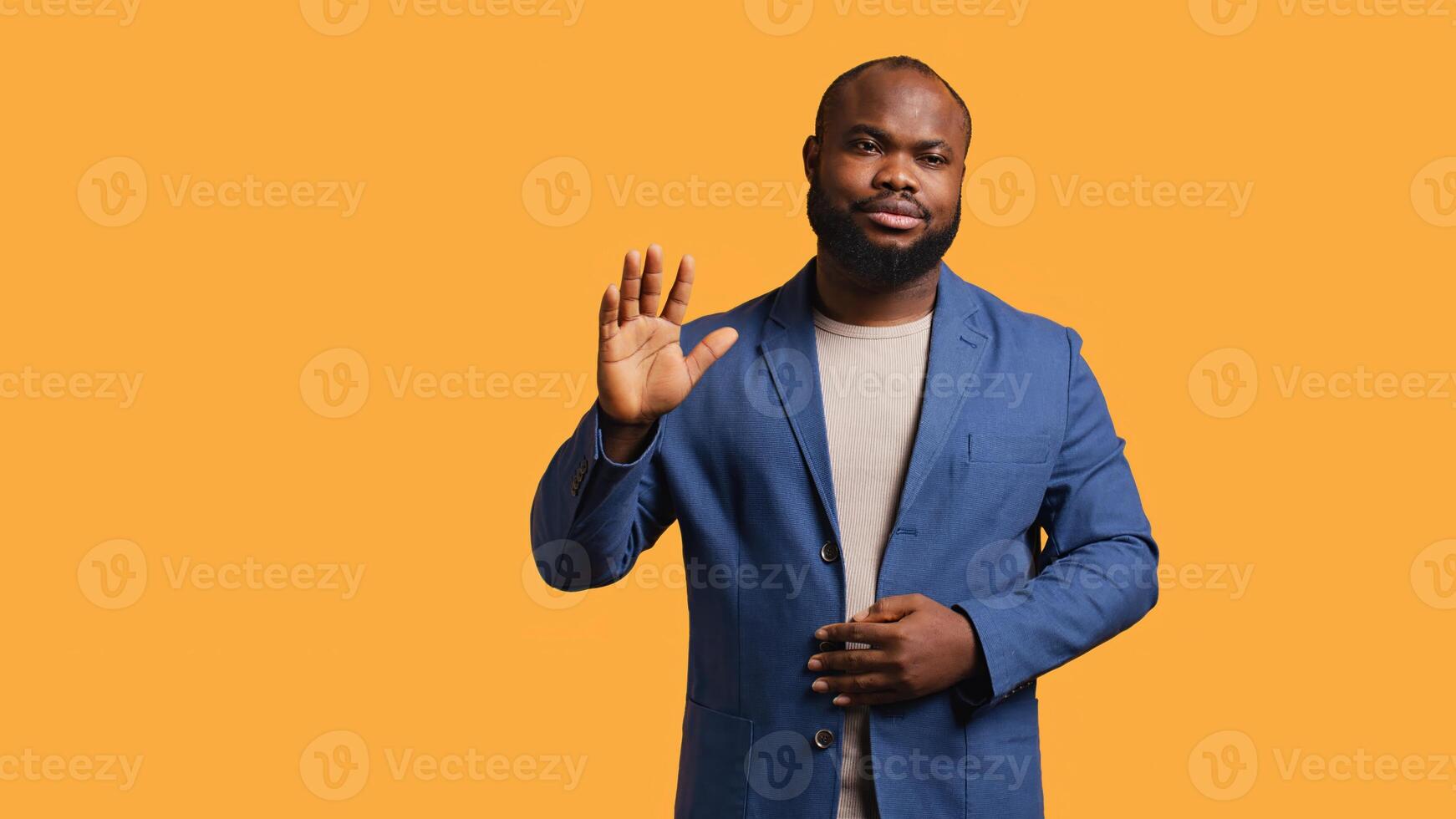 African american man reluctantly doing salutation hand gesture, saying goodbye. Portrait of sad BIPOC person raising arm to greet someone after leaving, isolated over studio background, camera B photo