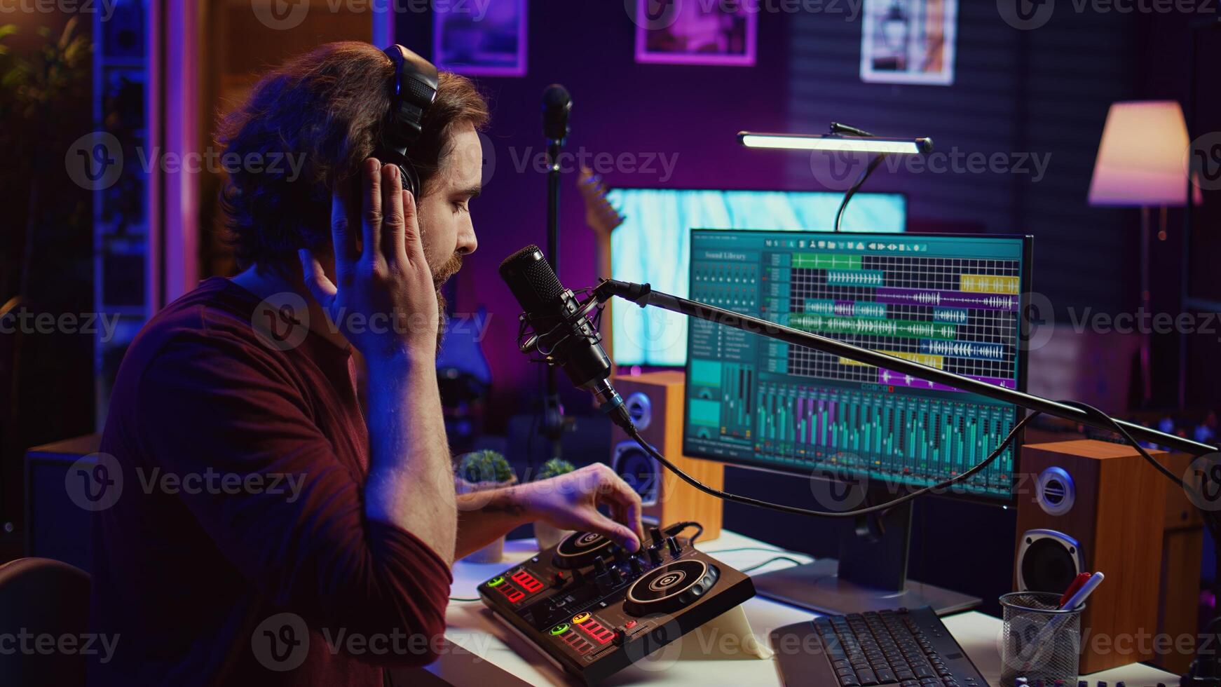 Sound producer recording backing vocals to add over tunes in home studio, using a mixing console to create a modern mix. Music producer mastering a new soundtrack with equalizer tool. Camera B. photo