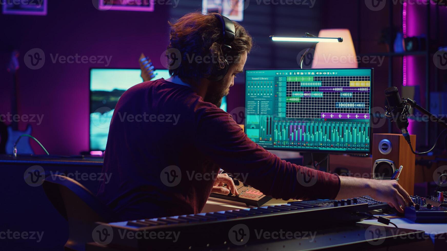 Music producer editing and mixing audio tracks on daw software, recording audio too loud with acoustical engineering technology. Sound engineer producing high quality recordings. Camera A. photo
