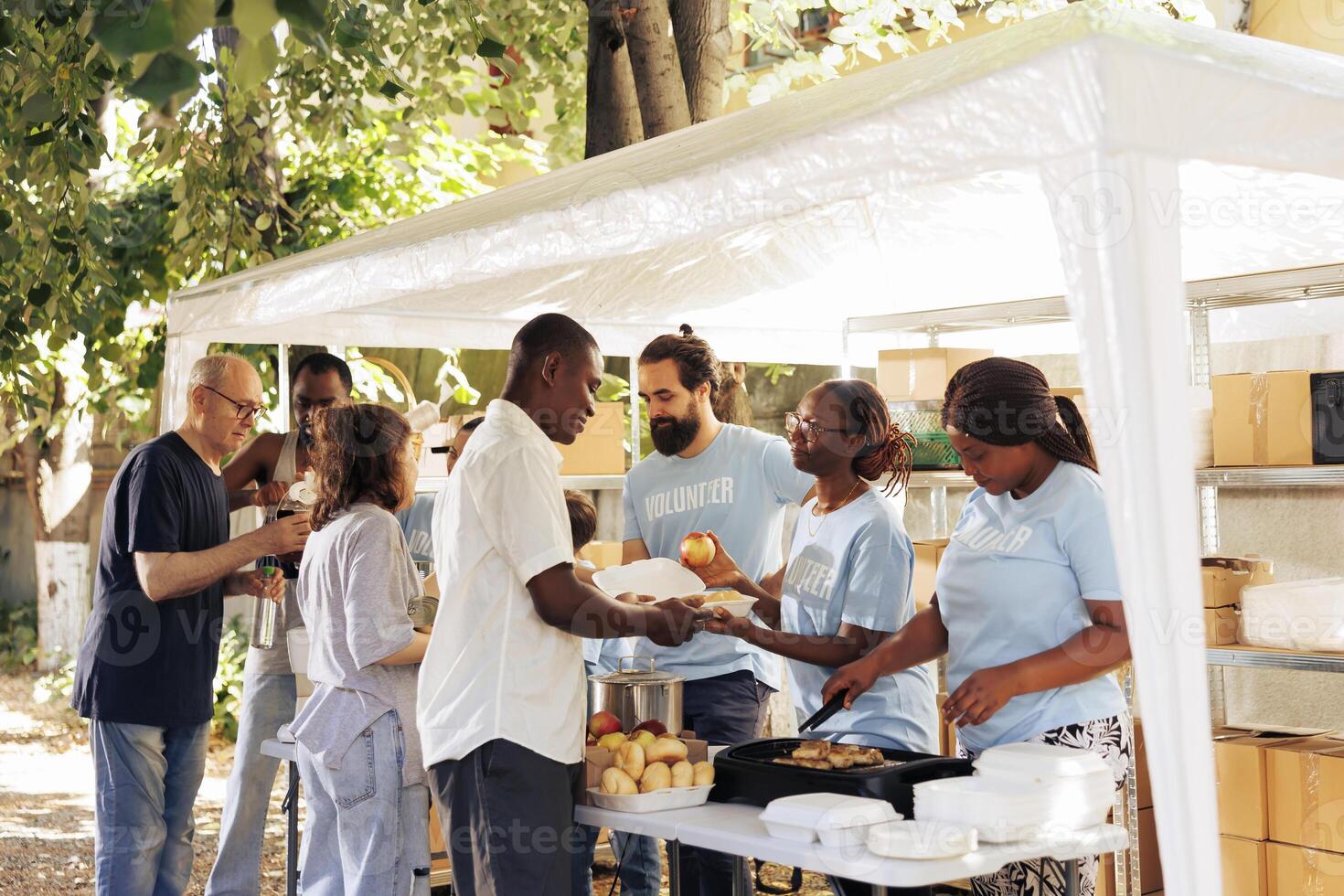 Multiethnic group of individuals collaborate at charity center, organizing a food drive to support the poor and needy. The selfless actions of volunteers provides hunger relief and humanitarian aid. photo