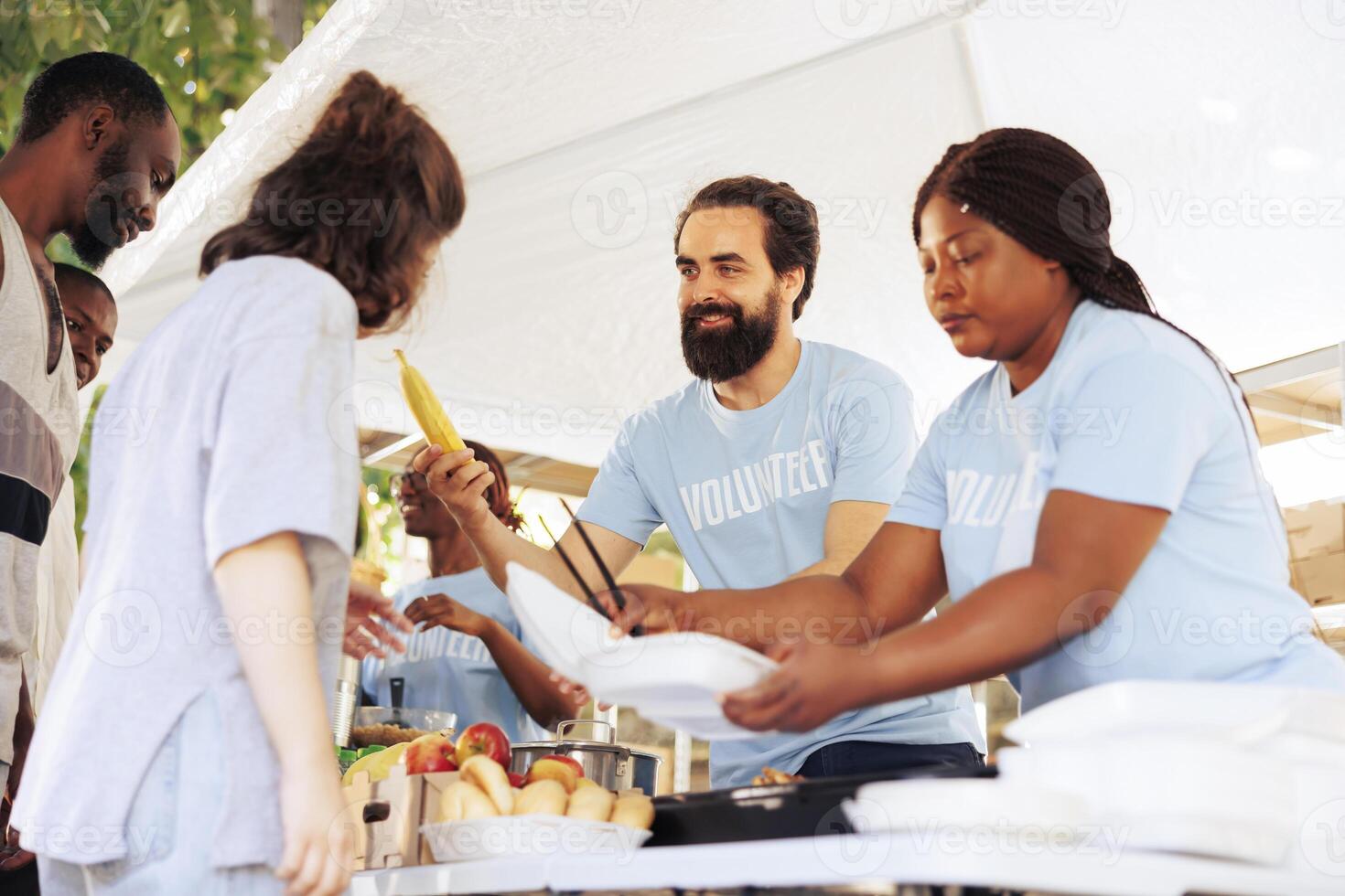 Hunger relief initiative providing essential items to the hungry and less fortunate. Friendly humanitarian aid team distributes food, offering support to poor, homeless people and refugees. photo