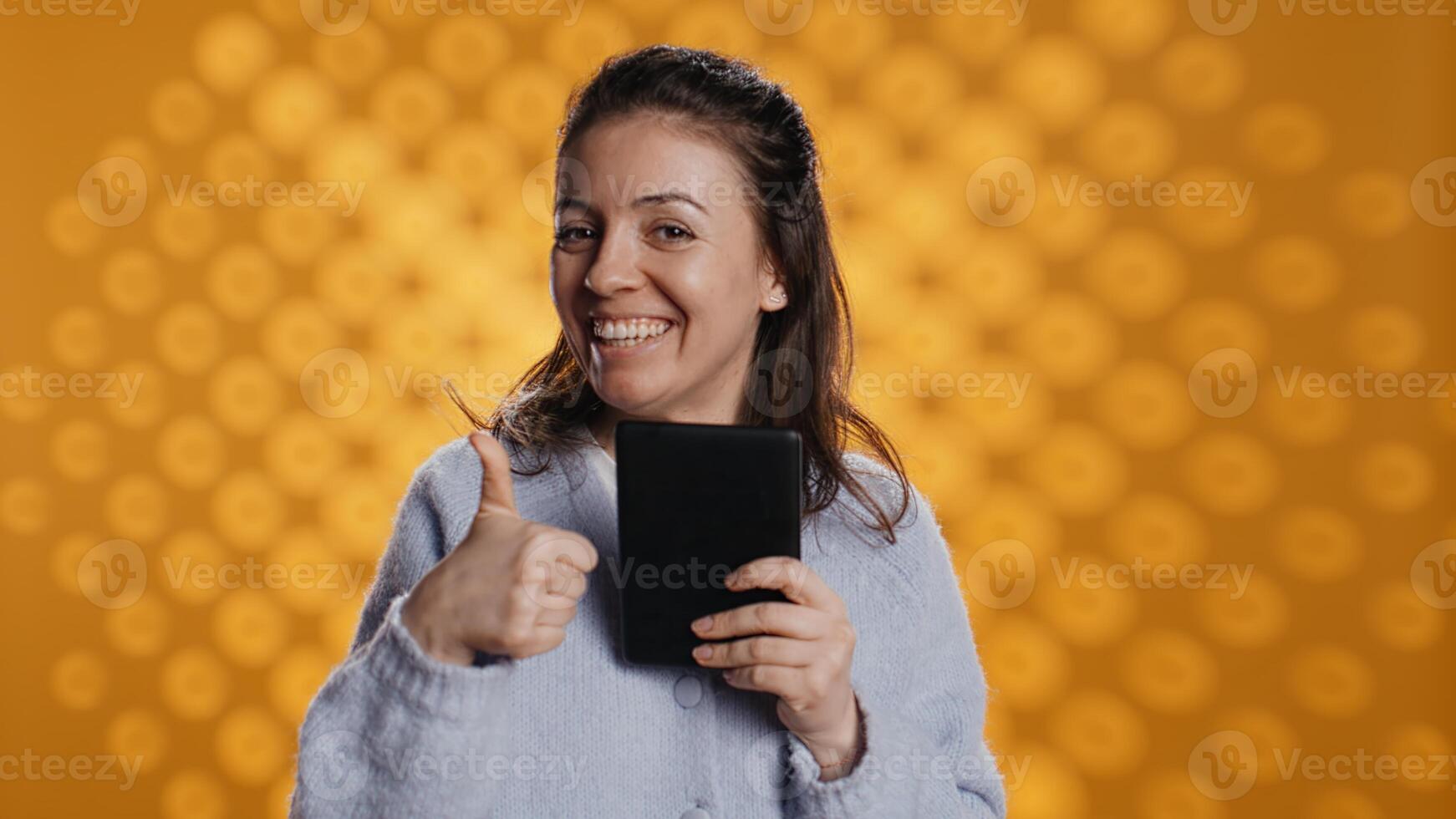 Woman choosing between physical books and ebooks, favoring ereader for lightness, studio background. Bookworm picking digital literature on tablet in front of heavy stack of novels, camera B photo