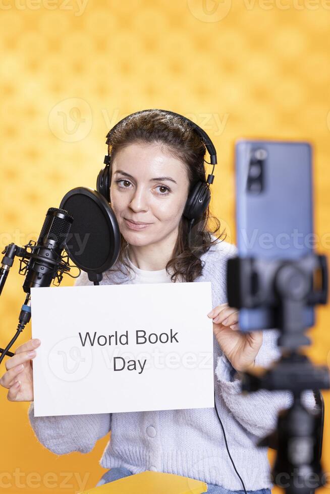 Woman Filming Promotional For World Book Day Using Microphone And Phone Woman Filming Promotional For World Book Day Using Microphone And Phone