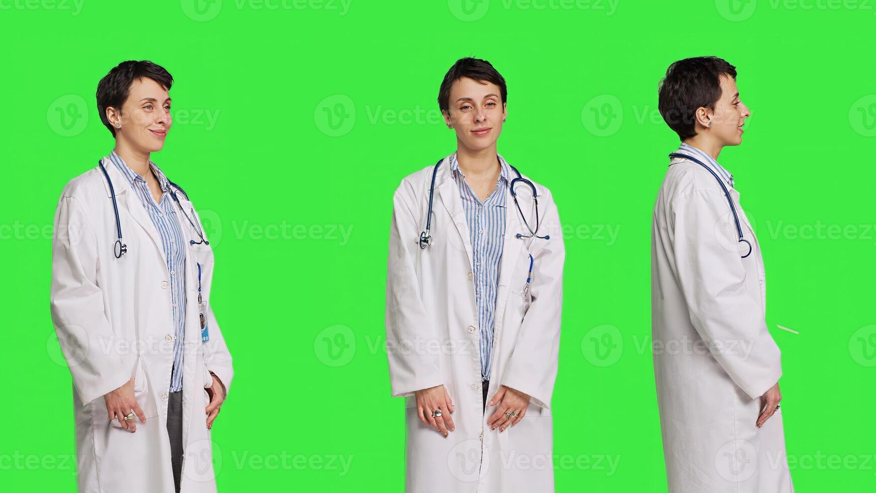 Portrait of physician wearing a white coat and a stethoscope for exams, standing against greenscreen backdrop. Doctor specialist working in healthcare industry, medical expertise. Camera B. photo