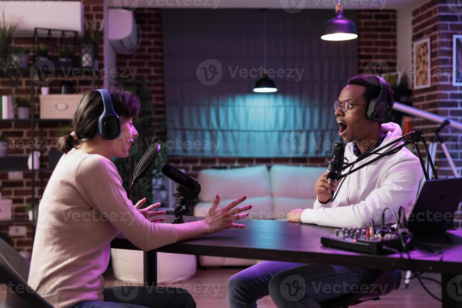 Woman on podcast talking with content creator during marathon streaming live broadcast for good humanitarian cause, gathering donations from viewers, entertaining audience from living room studio photo