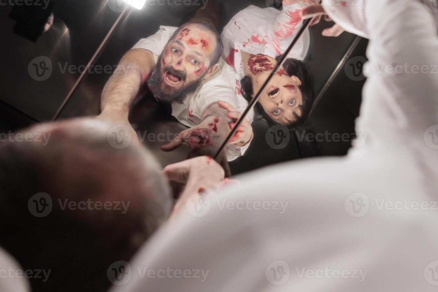 People infected by virus during outbreak turned into zombies looking in elevator mirror. Devil reanimated corpses filled with blood and scars stuck in escalator during apocalypse photo
