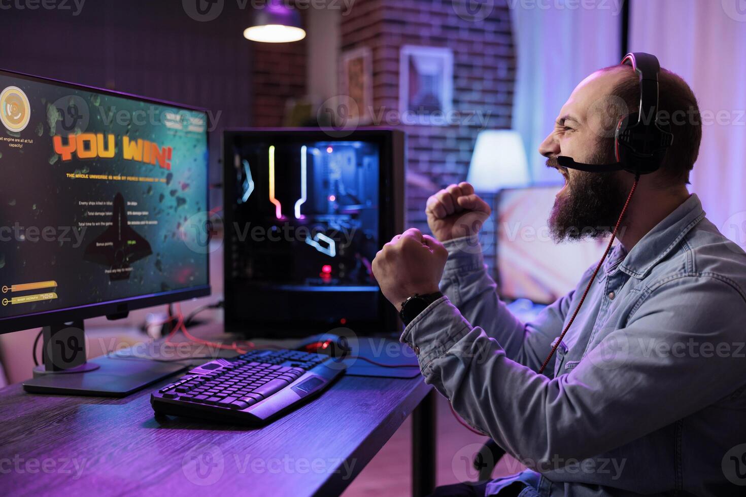 Gamer excited after killing other players in online multiplayer shooting game and winning championship. Man releasing pent up emotions, doing victorious yelling after defeating combatants photo