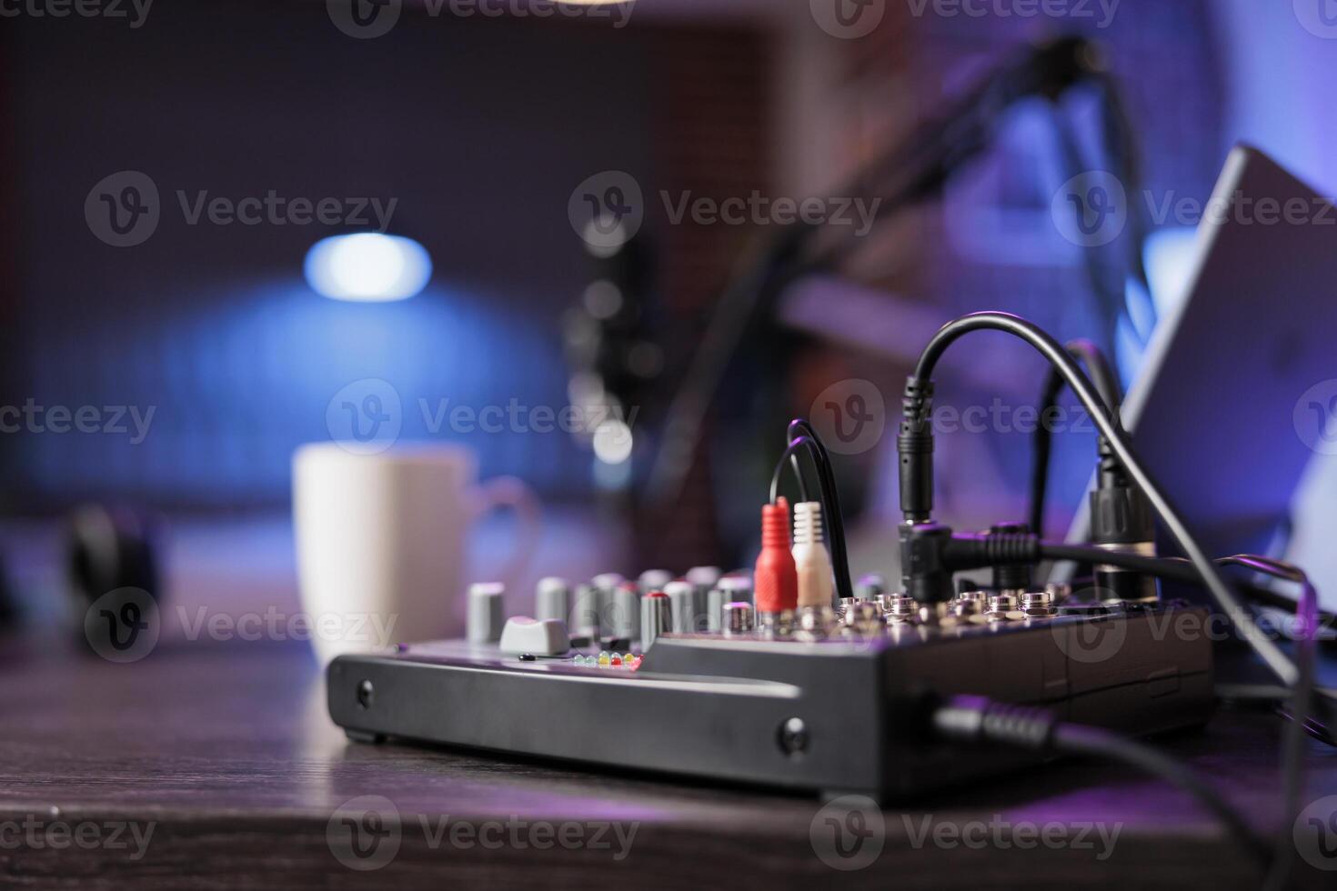 Close up shot of professional radio equipment used in home personal studio by dj to produce music and record online show. Empty living room with neon lights and entertainment device photo