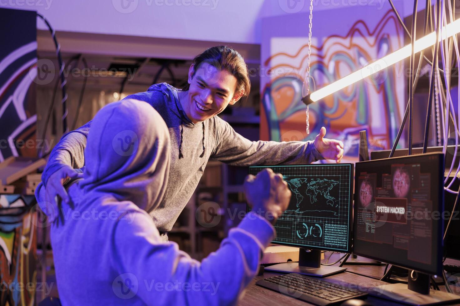 Successful criminals gaining unauthorized access to computer network and celebrating with victory gesture. Happy internet scammers getting system hacked message on screen photo