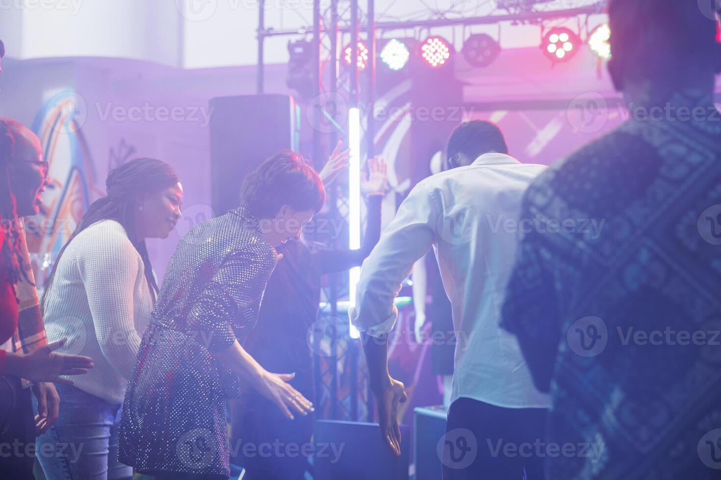 alegre clubbers riendo mientras improvisando danza batalla a discoteca en Club nocturno. despreocupado hombre y mujer amigos demostración se mueve en pista de baile mientras teniendo divertido a club fiesta foto