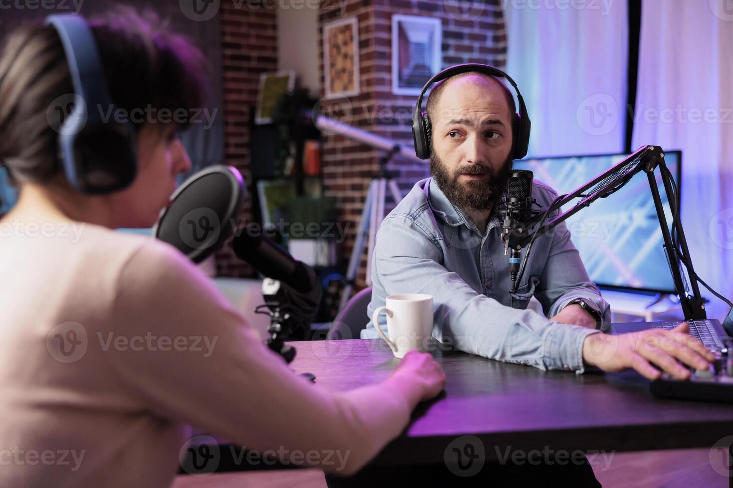 Show presenter interviewing designer during live stream, talking about fashion and style trends. Man having conversation with social media influencer, recording episode for podcast photo