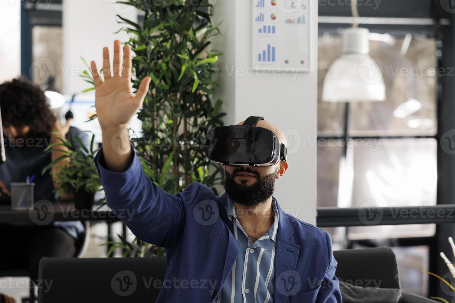 Businessman in virtual reality headset working in start up business office. Company employee exploring metaverse and brainstorming in vr glasses in corporate coworking space photo