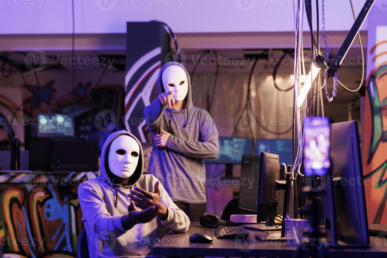 Internet thieves streaming ransom and demanding for payment and privacy information. Criminals in anonymous masks threatening to share personal password on mobile phone camera photo