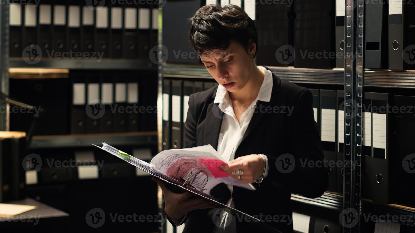 Criminal experts finding case clues in confidential record files, conducting investigation to solve crime in incident room. Detectives reading classified documents, secret mission. Handheld shot. photo