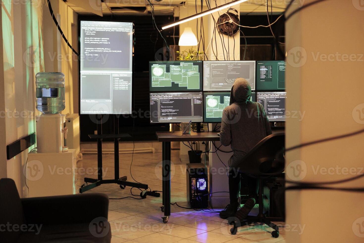 Young hacker working on multiple monitors to hack online server, cracking firewall encryption to steal passwords. Professional thief looking at screen planting trojan virus at night. photo