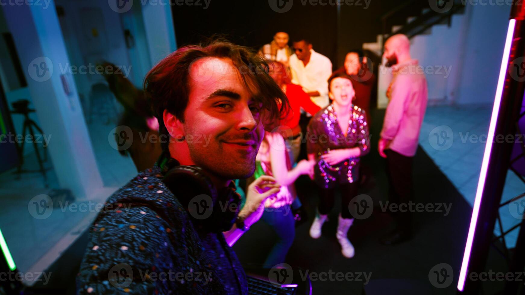 POV of funky DJ filming vlog on stage, mixing music at audio station panel and partying with people at nightclub. Cheerful man recording on smartphone, clubbing. Handheld shot. photo