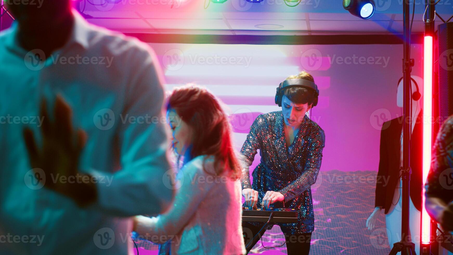 Diverse people dancing on music at club having fun and drinking alcohol, cheerful group of friends enjoying nightlife partying on the dance floor. Men and women clubbing celebration. photo