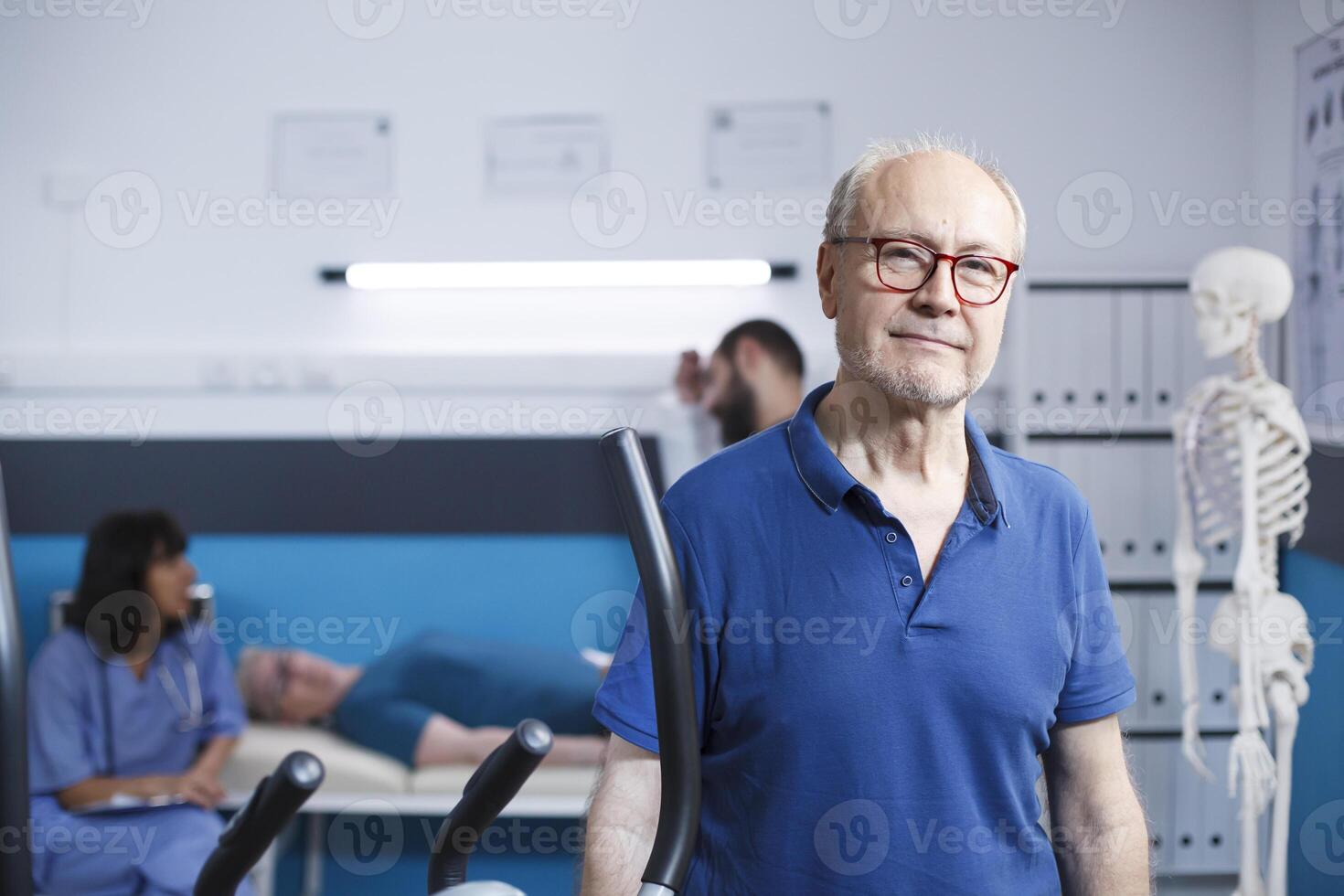 retrato de retirado paciente visitando físico terapia centro. mayor antiguo hombre mirando a el cámara, preparando a recuperar vía ejercicio y aptitud a un rehabilitación tratamiento clínica. foto