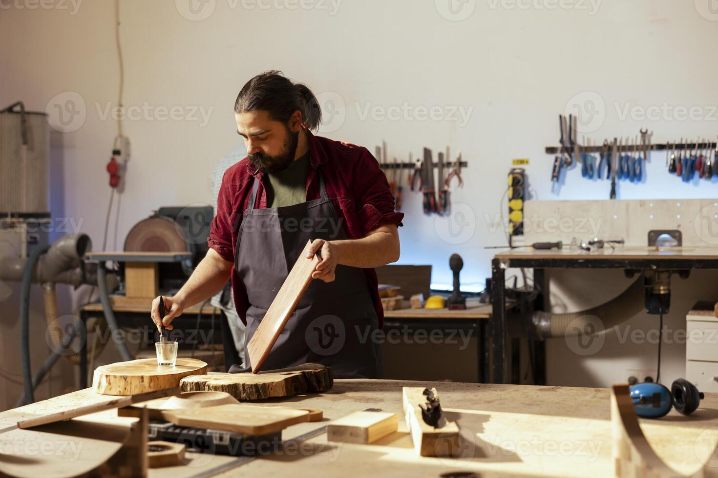 ebanista aplicando barniz en de madera superficie a evitar dañar y proporcionar capa de proteccion. carpintería especialista en carpintería tienda haciendo refinamiento en madera tablón, poniendo abrigos de petróleo foto